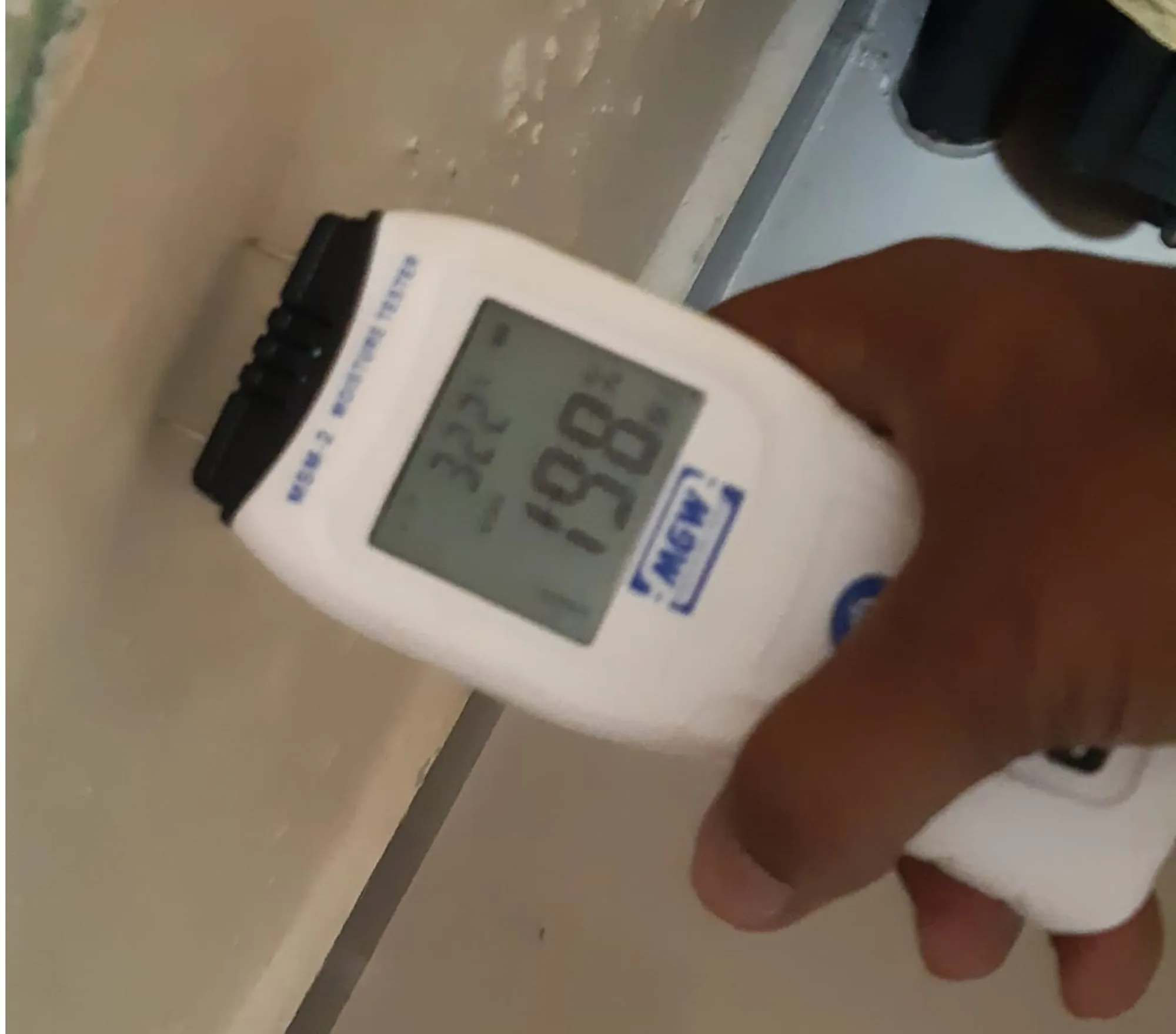 Moisture meter testing a wall before treatment — Mahadev Waterproofing